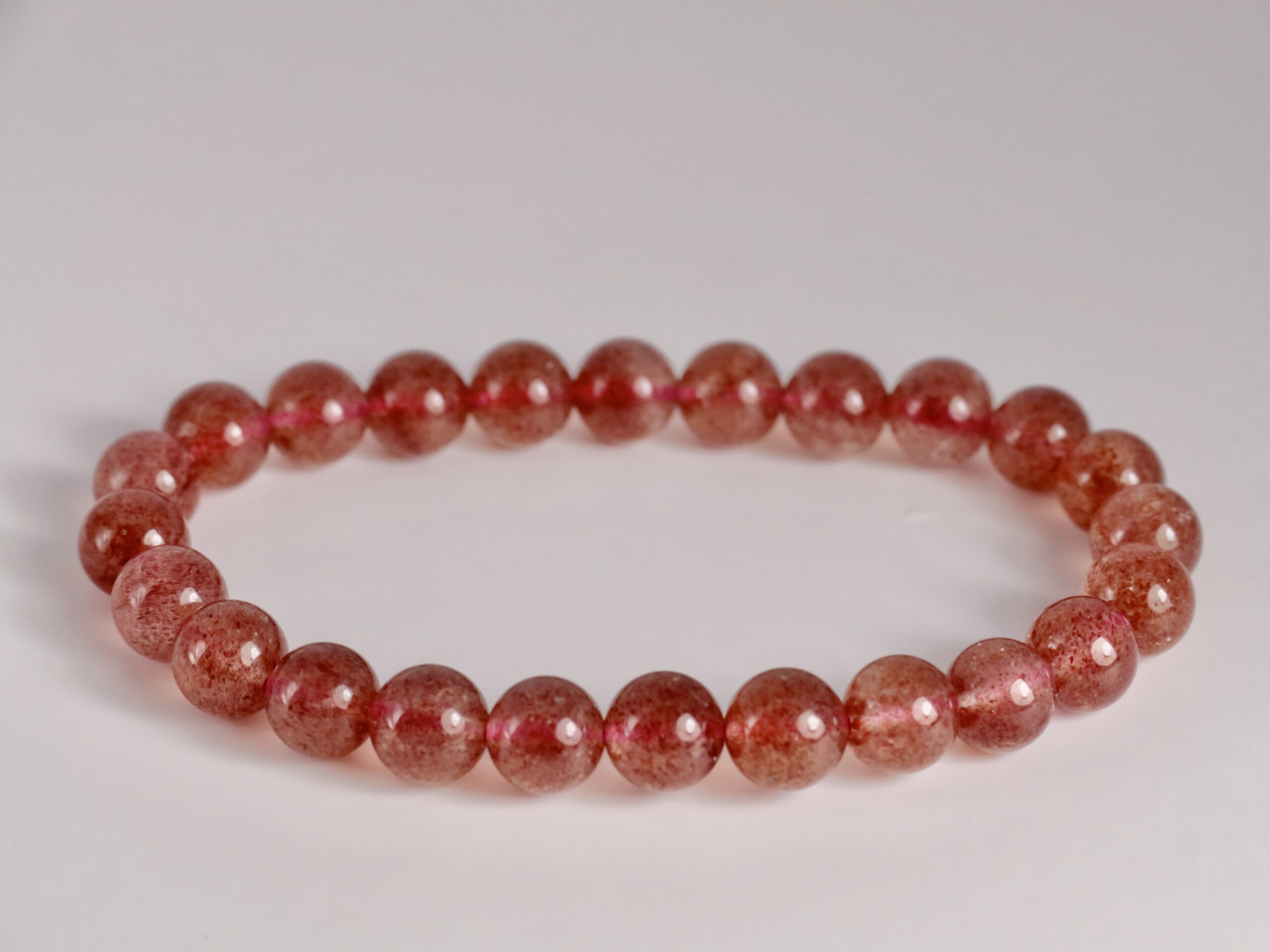 Bracelet rond en pierres roses translucides, perles lisses alignées, aspect naturel et apaisant. correspond à la lithothérapie et au port au quotidien.